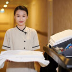 Portrait of smiling hotel maid holding stack of fresh fluffy flowers